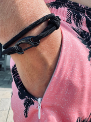 Man wearing a black black braided rope bracelet.